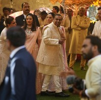 Tampak sang ayah yang sedang berbahagia, Mukesh Ambani, mengenakan pakaian tradisional di antara anggota keluarga lainnya. Foto: REUTERS/Francis Mascarenhas