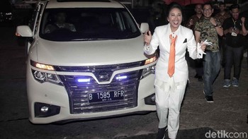 Disana Rini tampil elegan mengenakan setelan jas serba putih dipadu dengan dasi berwarna merah.