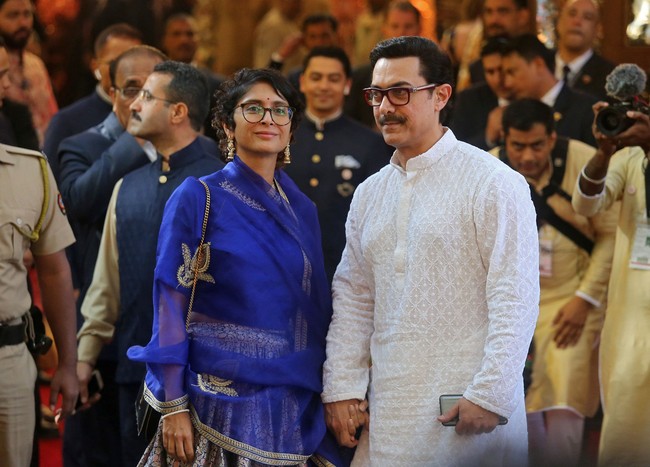 Aamir Khan yang datang bersama istri, Kiran Rao, memilih busana tunik dengan aksen emboss. Sementara Kiran memilih tampilan bold dengan busana warna biru elektrik. Foto: REUTERS/Francis Mascarenhas