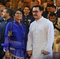 Aamir Khan yang datang bersama istri, Kiran Rao, memilih busana tunik dengan aksen emboss. Sementara Kiran memilih tampilan bold dengan busana warna biru elektrik. Foto: REUTERS/Francis Mascarenhas