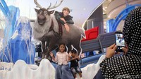 Sejumlah anak-anak befoto dengan latar belakang karakter-karakter yang ada di dalam film Frozen.