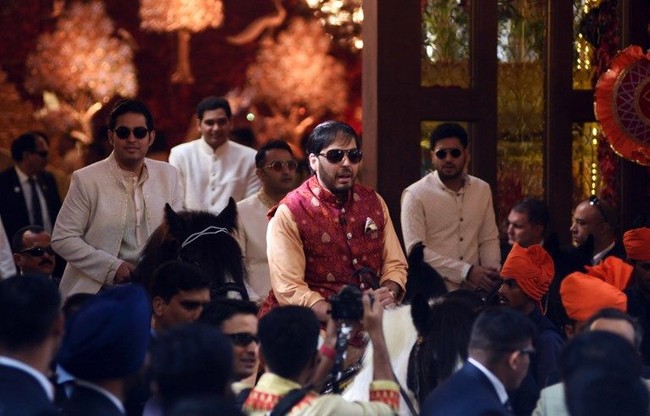 Kakak dan adik Isha Ambani, Akash Ambani dan Anant Ambani mengendarai kuda menuju tempat prosesi upacara pernikahan Isha Ambani dan Anand Piramal. Foto: AFP