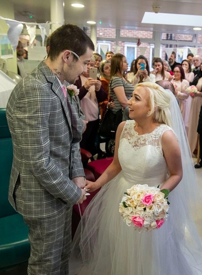 Pasangan Darren Easton dan Lauren Pope menderita penyakit yang sama cystic fibrosis, yakni penyakit yang menyebabkan lendir-lendir di dalam tubuh menjadi kental dan lengket, sehingga menyumbat berbagai saluran, terutama saluran pernapasan dan pencernaan. Darren mengumpulkan semua kekuatannya untuk berdiri dari kursi roda dan menikahi pujaan hatinya di Rumah Sakit Harefield, Hillingdon, London. Foto: dok. Maria Ashby-Giles Photography