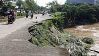 Sejumlah pengendara motor melintas di Jalan Cipendawa, Kota Bekasi, Jumat (14/12/2018), yang dibiarkan terbengkalai tidak adanya perbaikan jalan akibat longsor.