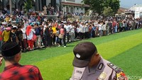 Massa terus merangsek maju, beberapa anggota Sapol PP membuat formasi melingkar untuk menjaga rumput sintetis agar tidak terinjak warga.