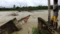 Seorang warga memperhatikan jembatan gantung penghubung Desa Meunuang Kinco dengan Desa Alue Keumang yang putus. ANTARA FOTO/Syifa Yulinnas.