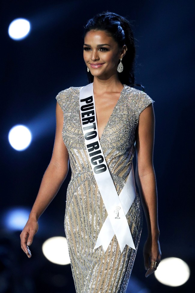 Miss Puerto Rico Kiara Ortega melangkah di panggung memakai gaun sequin perak membentuk tubuhnya. Embroidery serta penempatan beads yang apik membuat gaun tampak mewah. Foto: REUTERS/Athit Perawongmetha