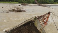 Jembatan gantung penghubung desa yang selesai dibangun pada akhir 2015 tersebut putus akibat penahan jembatan roboh terkikis air. ANTARA FOTO/Syifa Yulinnas.