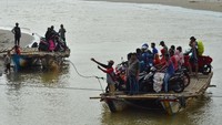 Warga bersama kendaraan bermotor menyeberangi sungai menggunakan perahu di Sungai Muara Cipatujah, Kabupaten Tasikmalaya, Jawa Barat. Antara Foto/Adeng Bustomi.