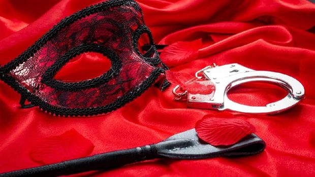 Blindfolded woman with red lip on black background