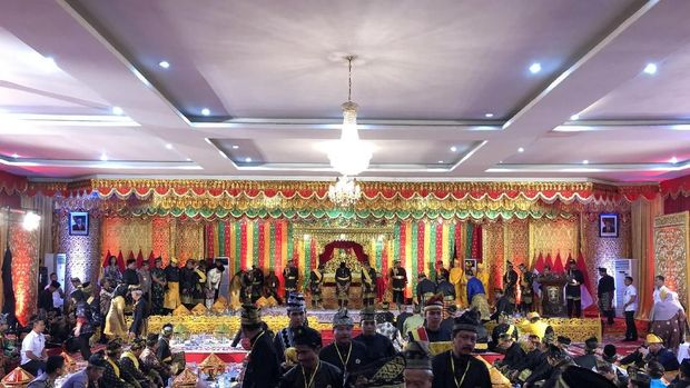  Jokowi tampak mengenakan pakaian adat khas Riau, yakni 'Teluk Belanga' warna hitam lengkap dengan kain songket. 