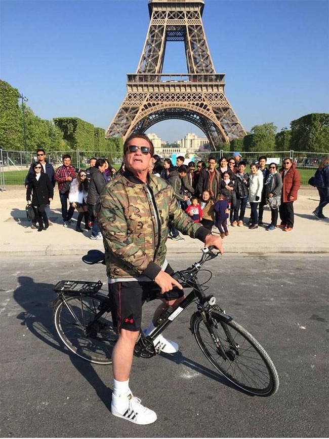 Photobomb selebriti paling epic. Arnold Schwarzenegger curi-curi kesempatan ikut berpose di depan saat rombongan turis membuat foto grup di depan Menara Eiffel. Bukannya kesal momen berfotonya diganggu, mereka justru senang. Foto: Dok. Bored Panda