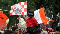 Mereka didandani orang tuanya dengan atribut layaknya orang dewasa seperti syal, baju, serta topi khas Persija Jakarta.