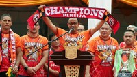 Ia membentangkan syal bertuliskan Champions Persija 