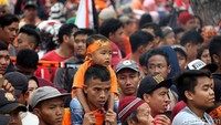 Seorang warga memanggul anaknya.