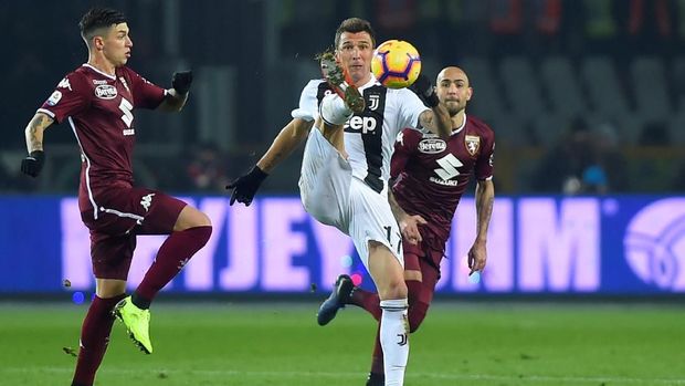 Mario Mandzukic mencoba mengontrol bola dikawal ketat pemain Torino. (