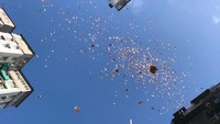 Uang kertas pecahan HK$ 100 tampak berjatuhan dari langit. Orang-orang yang ada di jalanan berusaha mengambil uang kertas yang berjatuhan itu, sedangkan yang lain merekam momen langka ini dengan telepon genggam mereka. Foto: Facebook