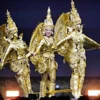 Berbeda dengan finalis lainnya, On-anong tampil tak sendirian saat memeragakan kostum nasionalnya. Dia naik ke atas panggung bersama dua boneka berwarna emas yang menyatu dengan dirinya. Miss Laos itu pun didandani sama persis berwarna emas dengan dua boneka yang bergerak seiring gerakannya tersebut. Foto: Instagram