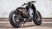Detail lainnya, pada suspensi teleskopik di depan disematkan semacam cover plastik, sehingga membuat bebek ini terlihat lebih kekar. Sementara itu, setang fatbarnya dibiarkan telanjang yang menambah kental suasana maskulin. Honda Super Cub modifikasi ini juga telah mengaplikasikan jok tunggal yang membuatnya semakin tampak klasik. Foto: Pool (carscoops)