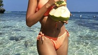 Main di pantai paling enak segarkan dahaga dengan es kelapa. Apalagi diminum langsung dari batoknya. Foto: Instagram catriona_gray