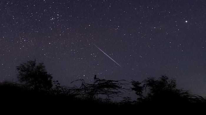 This photo taken late December 14, 2018 with a long time exposure shows a meteor streaking through the night sky over Myanmar during the Geminid meteor shower seen from Wundwin township near Mandalay city. (Photo by Ye Aung THU / AFP)