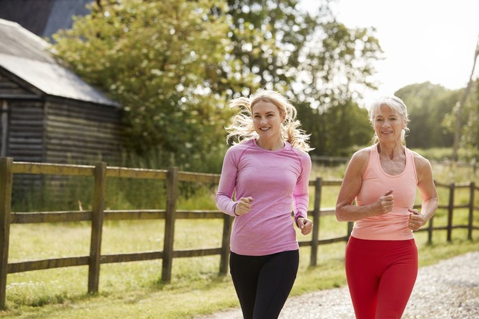 Lets take a picture for social network! Close up portrait of beautiful sportive cute gentle tender mother and daughter wearing sporty clothes making video call via internet connection