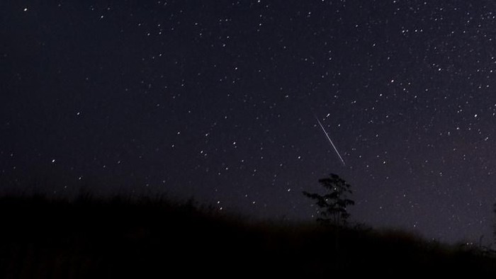 This photo taken late December 14, 2018 with a long time exposure shows a meteor streaking through the night sky over Myanmar during the Geminid meteor shower seen from Wundwin township near Mandalay city. (Photo by Ye Aung THU / AFP)