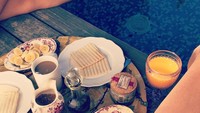 Lagi-lagi bersantai di pinggir kolam renang. Tapi kali ini tak hanya ditemani minuman dingin, tapi juga buah, roti, smoked beef, dan segelas jus. Foto: Instagram angelaponceofficial