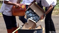 Petugas memasukkan e-KTP rusak ke dalam drum untuk dibakar.