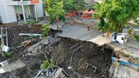 Di lokasi amblesnya tanah, ada alat berat yang tertimbun.