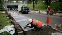 Sejumlah pekerja nampak mengerjakan proyek pembangunan trotoar di kawasan kolong jembatan Semanggi, Jakarta, Kamis (20/12/2018).