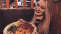 Calzones seperti pizza hanya saja lebih sulit dimakan, kata Polly yang juga cantik memakai lipstik warna gelap. Foto: Instagram pollyoddsocks