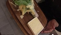 Seorang wanita di Afrika, mengabadikan momen saat ia makan di restoran mewah. Di mana Caesar salad pesanannya, disajikan di atas kayu, dengan sayuran masih terikat rapih, dan irisan keju yang berantakan. Duh! Foto: Twitter/Istimewa