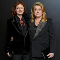 Jas tersebut membungkus blus berwarna senada yang hadir dengan dasi ruffle bergaya vintage. Menariknya, bintang Enchanted ini menyempurnakan gayanya dengan pita berbentuk kepiting tiruan. Foto: Mike Coppola/Getty Images