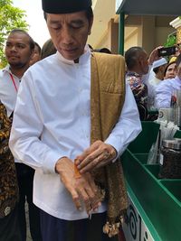 Jokowi memasang plester di tangannya.