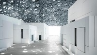 Salah satu daya tarik utamanya adalah kubah silver berlubang-lubang dengan pola arabesque di atas galeri seni. Cahaya yang masuk ke dalam ruangan menghasilkan refleksi yang cantik, juga disebut sebagai hujan lampu (Louvre Abu Dhabi)