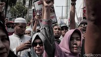 Para peserta aksi terlihat membawa bendera bertuliskan kalimat tauhid dan spanduk-spanduk yang memprotes dugaan penindasan terhadap muslim Uighur di China.