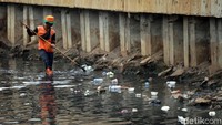 Petugas PPSU nampak membersihkan sampah di Kali Grogol, Jakarta, Jumat (21/12/2018).