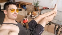 Berpose dengan anjing kesayangannya, Clint terlihat selesai berolahraga. Ia sepertinya sedang menikmati sebotol protein shake. Foto: Instagram clintbondad