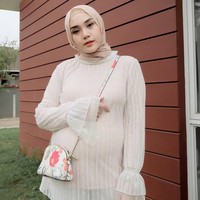 Begitupun dengan pilihan atasannya. Ranie memilih busana yang loose dengan bagian perut yang longgar. Tak jarang ia memilih detail pita di bagian perutnya sehingga terlihat imut. Foto: Instagram/RanieKarlina