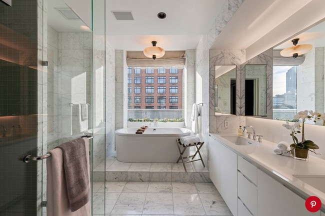 Kamar mandi mewah serba putih berlantai marmer. Pada bagian bath tub juga terdapat jendela kaca besar yang berhadapan langsung dengan gedung berwarna merah bata. Foto: Dok. People/Stribling & Associates