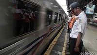 Para petugas doa bersama melepas keberangkatan kereta api.