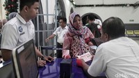 Petugas mengecek tiket penumpang kereta api.