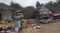 Tampak dua buah mobil yang berada di antara rumah-rumah yang rusak di Kecamatan Cinangka. (Bahtiar/detikcom)