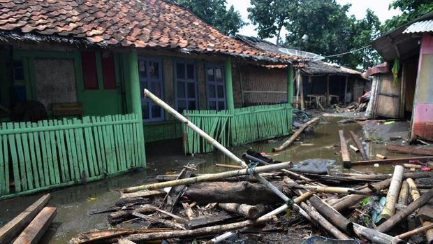 Tumpukan kayu dan bambu yang terhempas gelombang tsunami berserakan di halaman rumah di Kampung Sindangsari, Kecamatan Panimbang, Pandeglang, Banten, Minggu (23/12/2018).