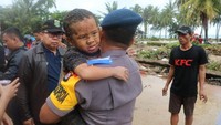 Bocah laki-laki itu kemudian digendong seorang polisi. Kaus dan wajahnya kotor.  (Foto: Dok. Mabes Polri)