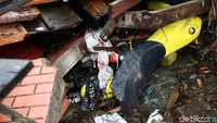 Satu unit motor tampak tertimpa reruntuhan rumah.
