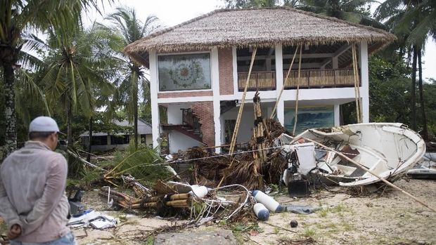 Warga berada di depan bangunan yang terdampak bencana Tsunami di Pantai Tanjung Lesung, Banten, Jawa Barat, Minggu (23/12/2018)