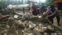 Polisi mulai membersihkan puing-puing bangunan akibat terhantam tsunami dan menutup jalan.