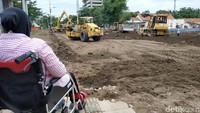 Meski masih duduk di kursi roda, Risma nampak serius memantau langsung proses perbaikan Jalan Gubeng.